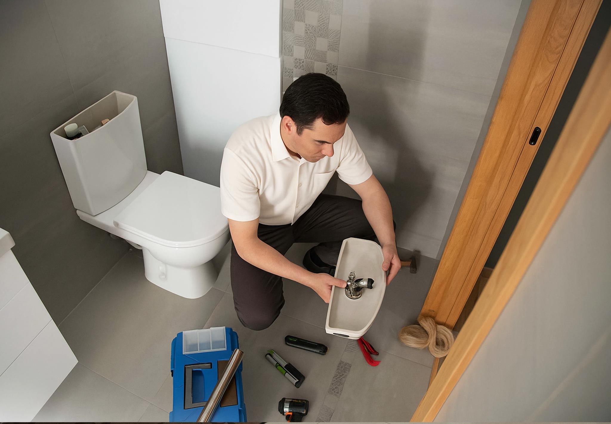 plumber working on toilet parts